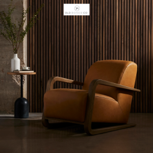 Lean into this dramatically shaped seating style upholstered in butterscotch-colored top-grain leather. U-shaped arms of solid oak wrap around the entire silhouette for an intriguing takeaway.